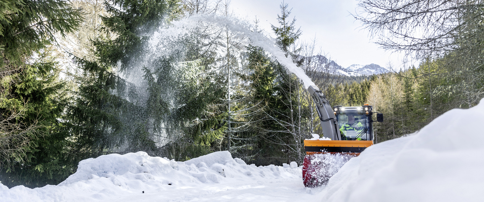 Snow blower in action a snow blower clearing a snow-covered road in winter