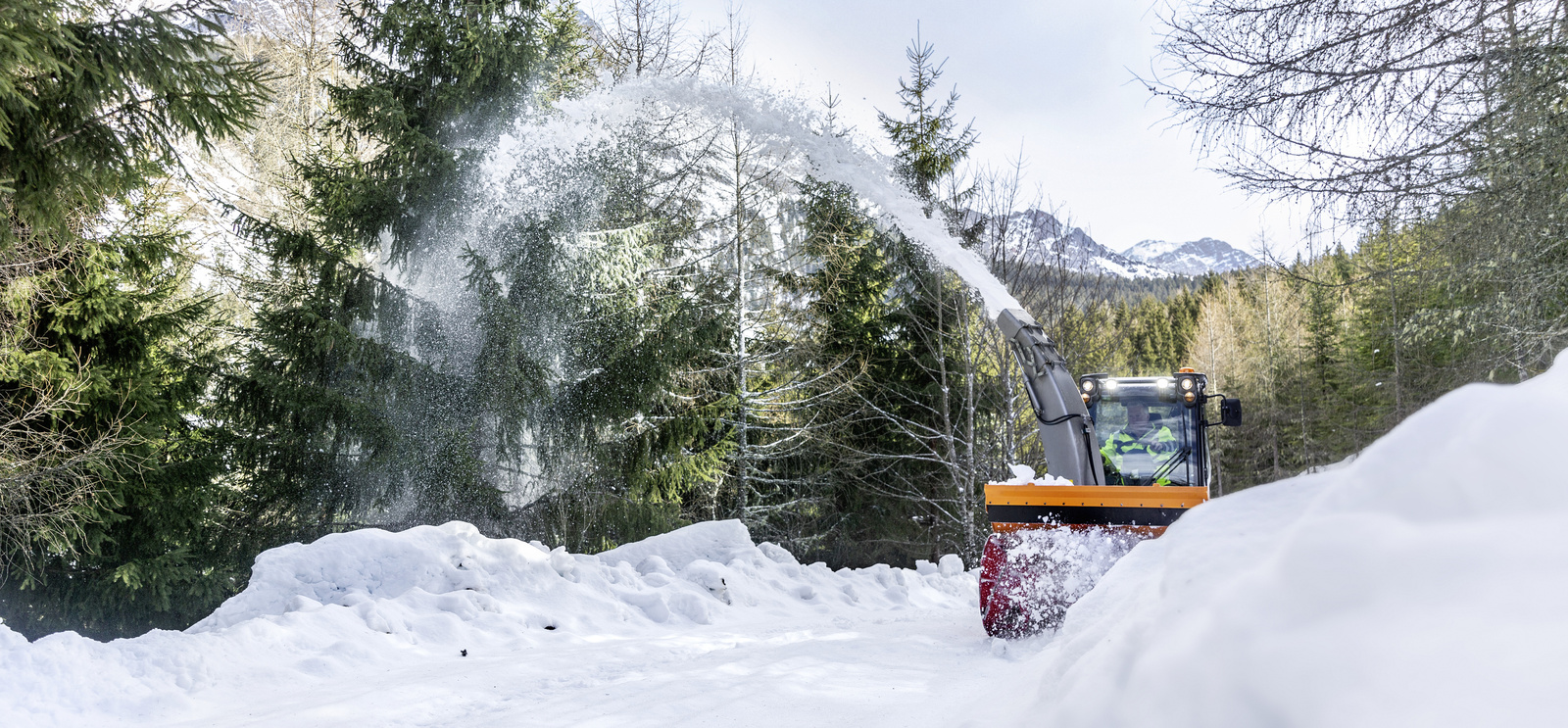 Winterdienst Eine Schneefräse befreit einen Weg vom Schnee