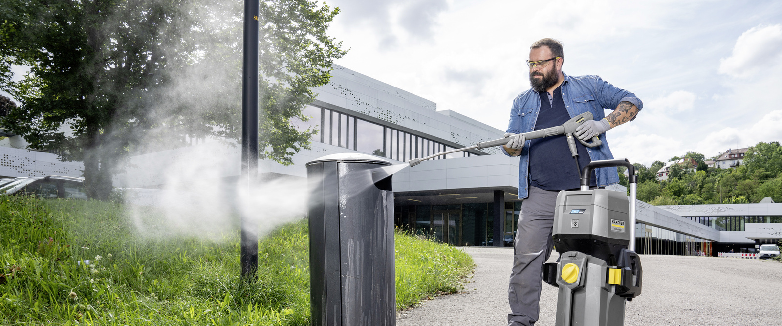 Hochdruckreiniger im Einsatz Eine Person säubert mit einem Hochdruckreiniger von Kärcher eine Mülltone