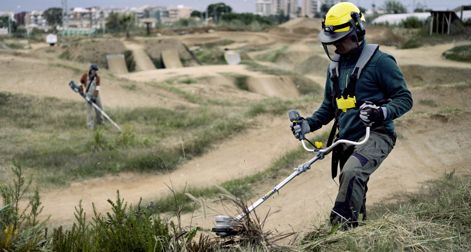 Grünpflege Ein Mann trimmt hohes Gras