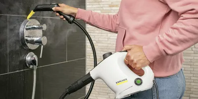 Person cleaning bathroom with Kärcher steam cleaner