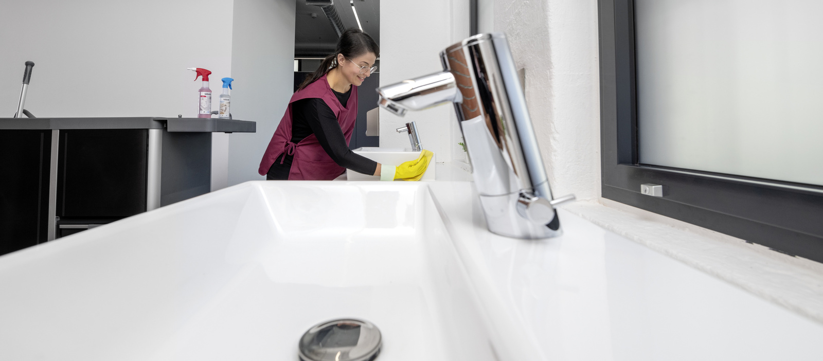 Cleaning of toilets A person is cleaning the sink in a sanitary facility