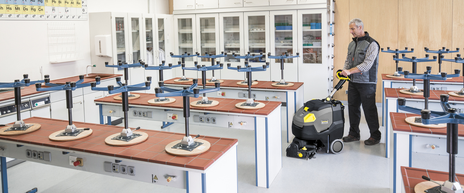 Cleaning schools and day nurseries A person operating a scrubber dryer in a classroom