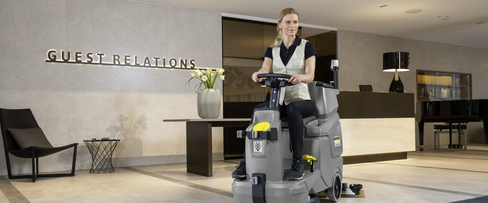 Cleaning hotels efficiently A person sitting on a scrubber dryer cleaning the hotel lobby