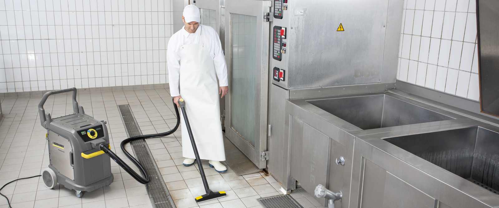Fliesenreinigung Eine Person säubert die Fliesen in einer Grossküche
