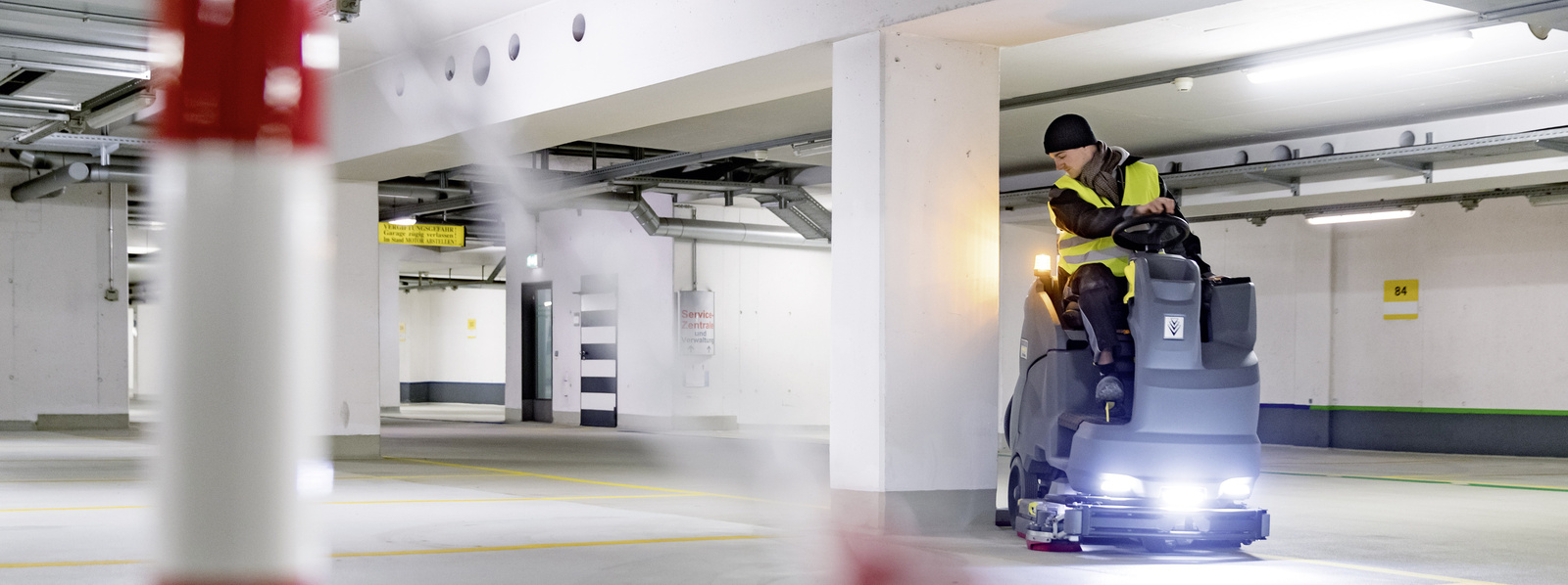 Cleaning parking garages A person operating a ride-on sweeper