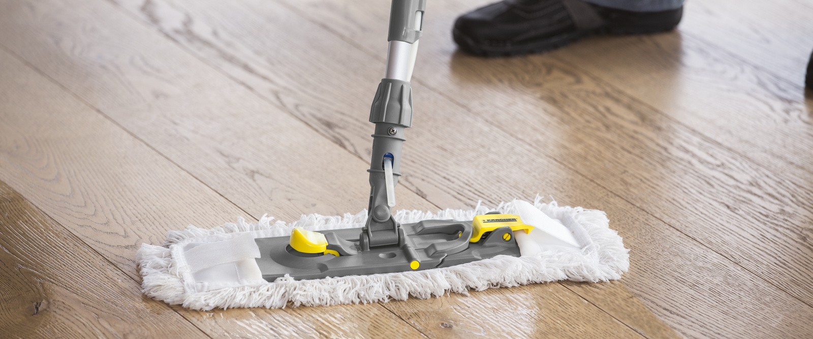 Manuelle Reinigung mit dem Sprüh-Moppsystem Eine Person wischt den Boden mit dem Sprüh-Moppsystem von Kärcher