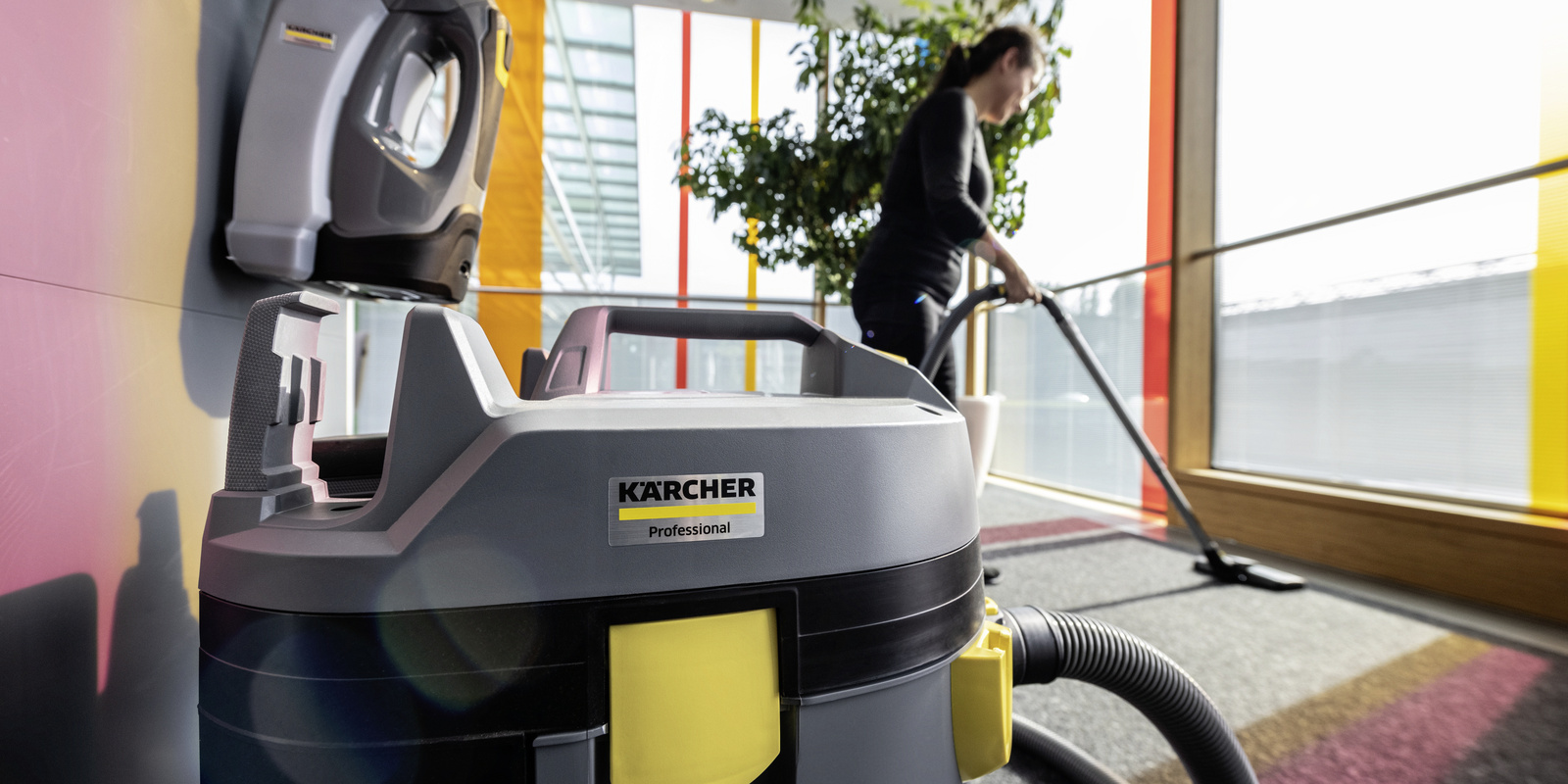Vacuum cleaner A person cleaning a school hallway with a dry vacuum cleaner