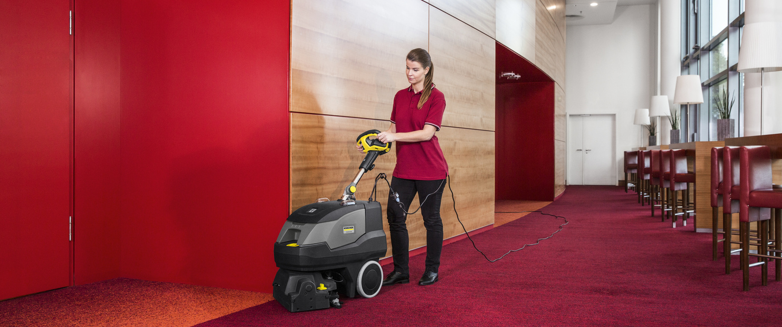 One person operates a vacuum cleaner for intermediate cleaning of the carpet
