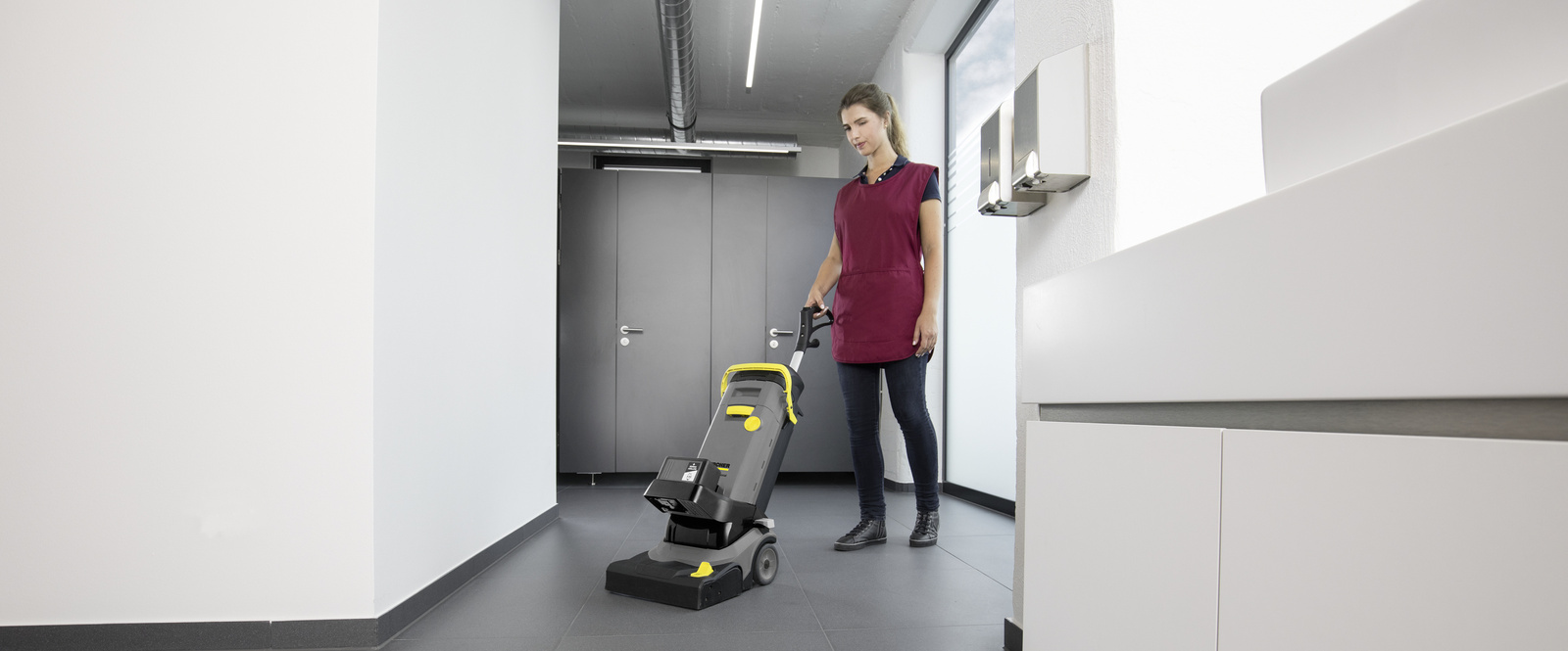 Scrubber dryer A person cleaning a sanitary area with a scrubber dryer