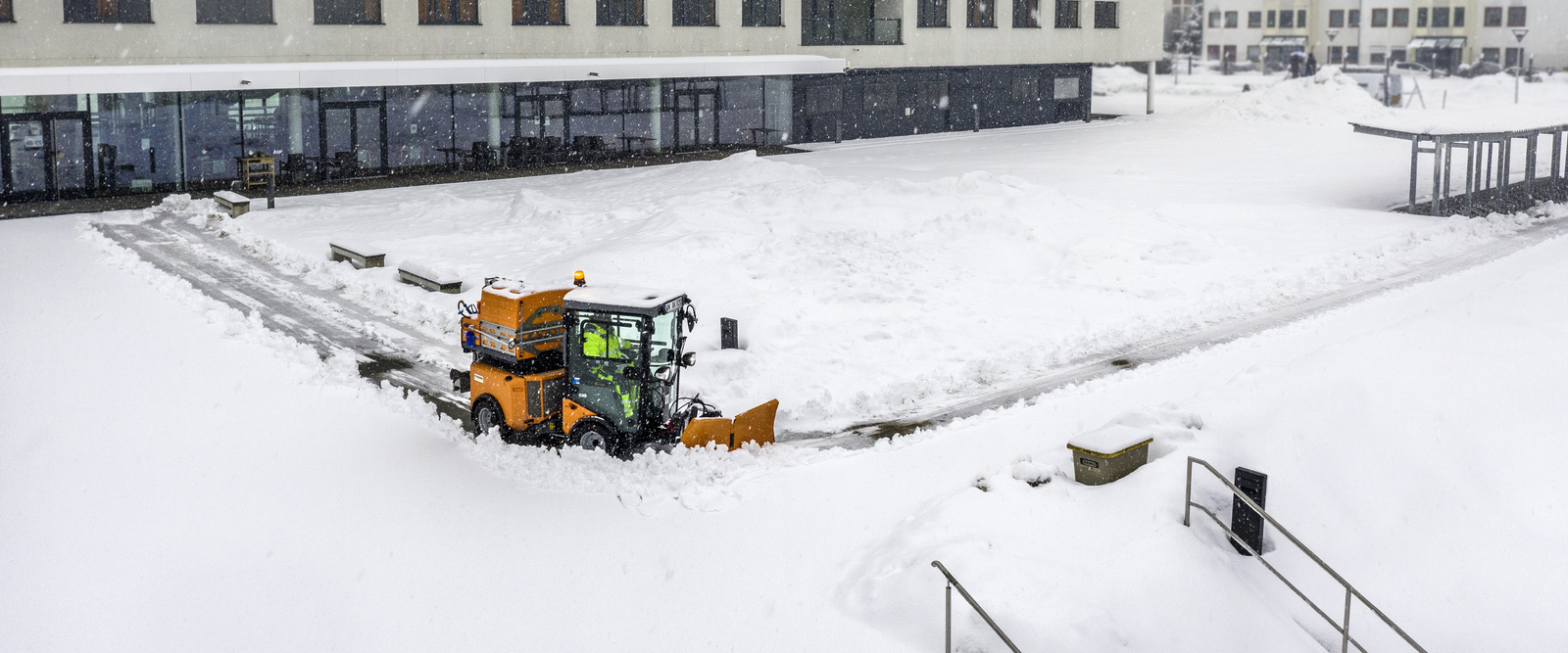 Winterdienst Ein Scheepflug befreit einen eingeschneiten Weg vom Schnee