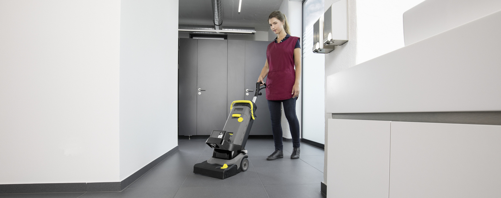 Sanitärreinigung Eine Person reinigt den Fußboden einer Sanitäranlagen