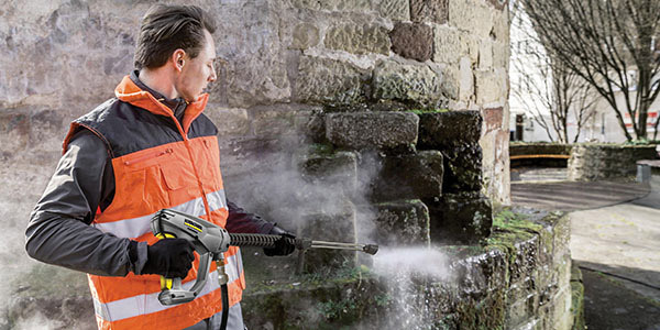 Portability A worker cleans moss of bricks with a gas pressure washer