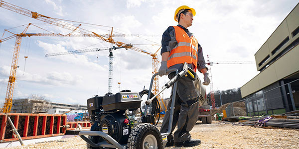 Easy Fuel Accessibility A worker moves a gas pressure washer in a construction site