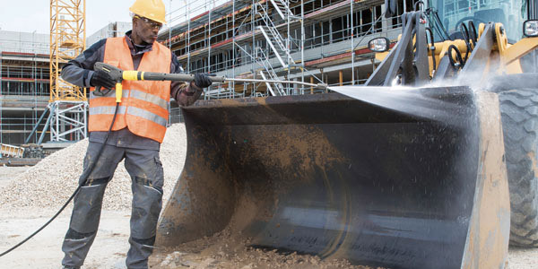 High Power Output A worker cleans construction equipment with a gas pressure washer