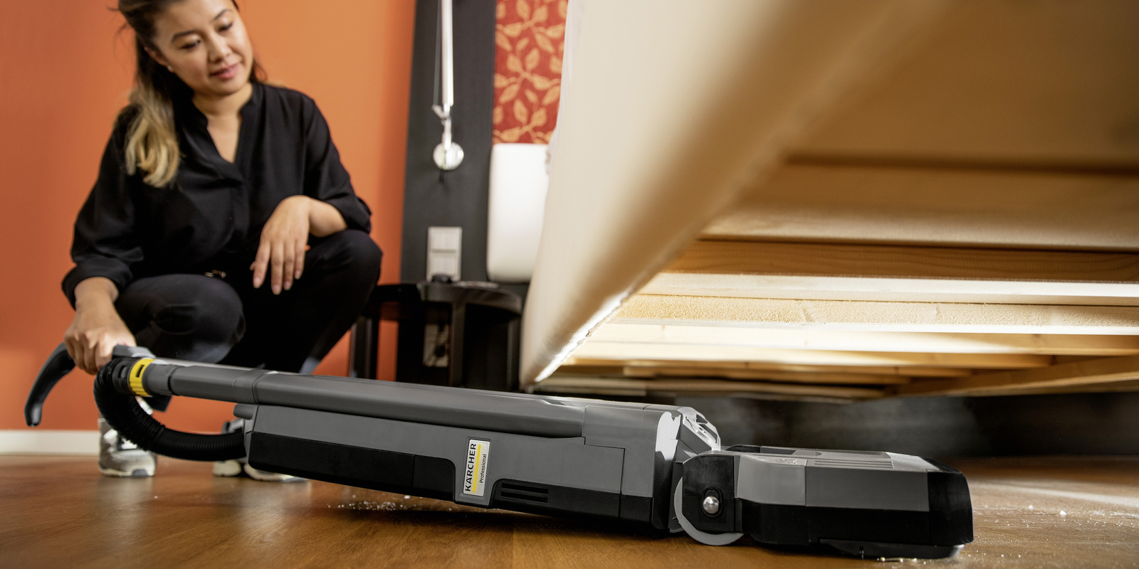 Carpet brush vacuum cleaner A person cleans the floor under a bed with the help of a carpet brush vacuum cleaner