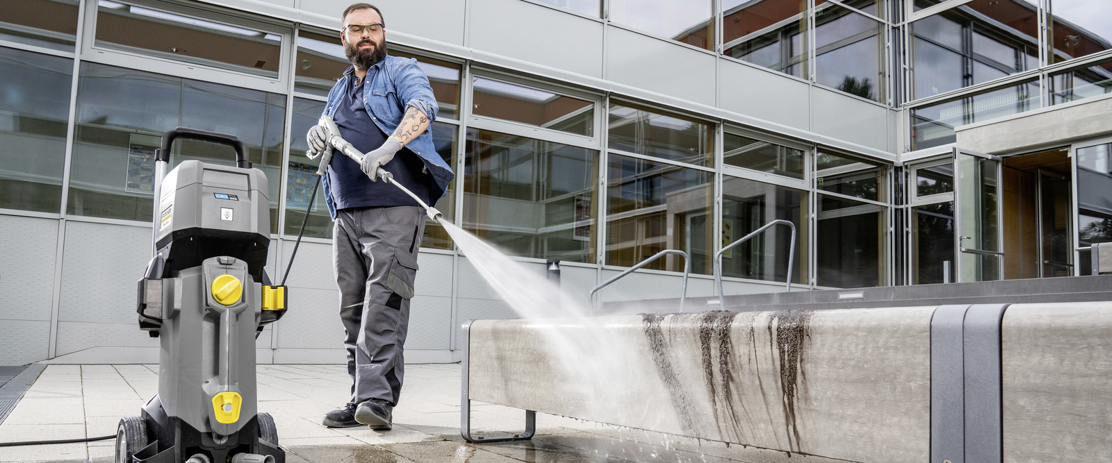 Hochdruckreiniger im Einsatz Eine Person reinigt den Außenbereich mit einem Hochdruckreiniger von Kärcher