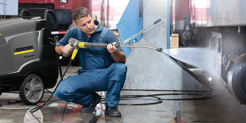 Advantages of Hot Water Pressure Washers A worker clean under a truck with a Kärcher hot water pressure washer