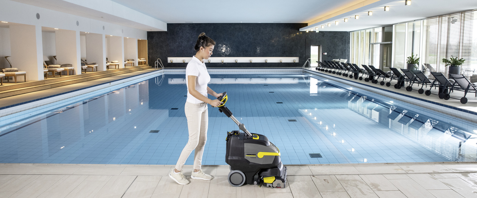 Efficiently cleaning swimming pools A person cleaning the edge of a swimming pool
