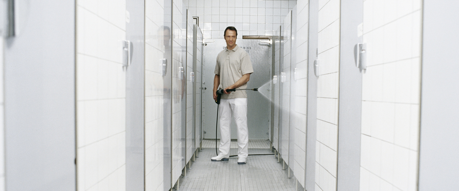 Steam cleaner in use A person cleaning shower cubicles with a steam cleaner