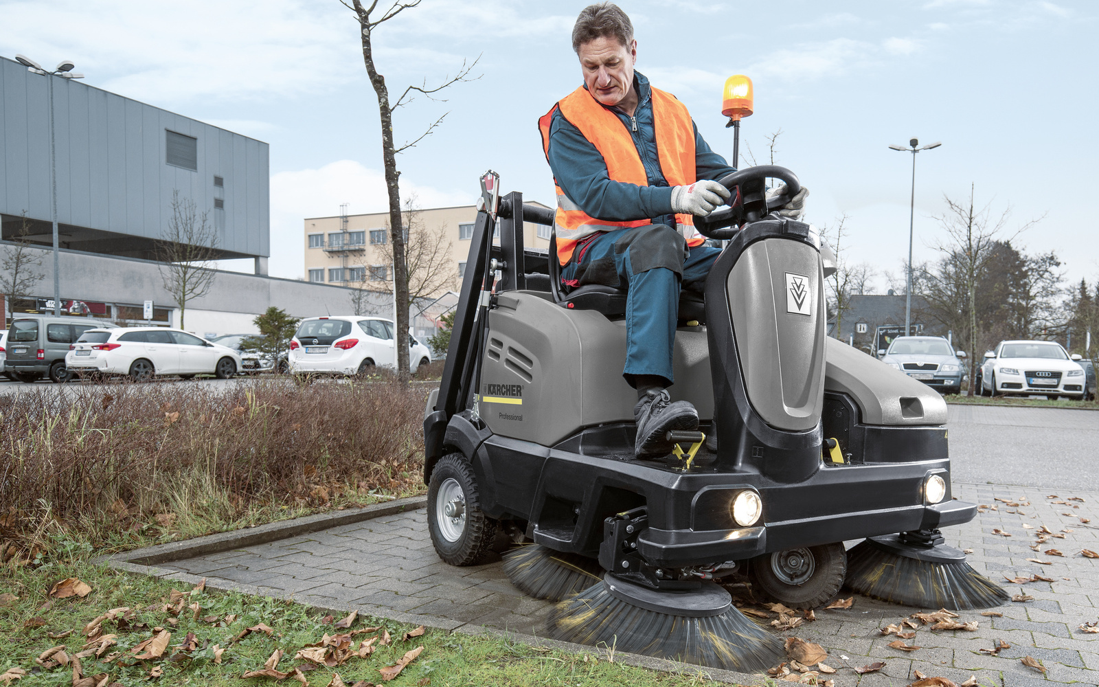 Cleaning outdoor spaces A person cleaning a parking lot with a sweeper