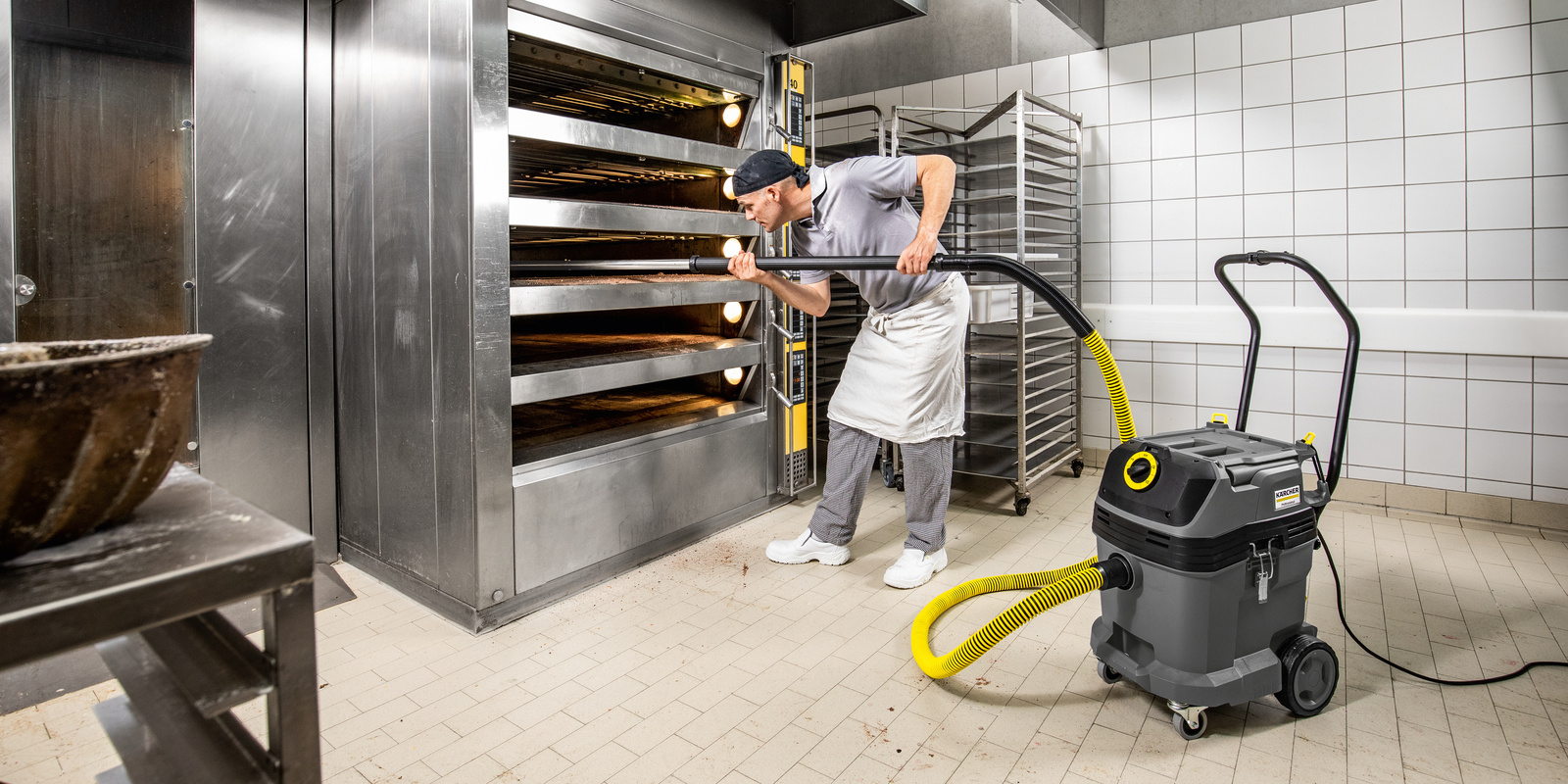 Bakery vacuum cleaner in use A person cleaning an oven with a bakery vacuum cleaner