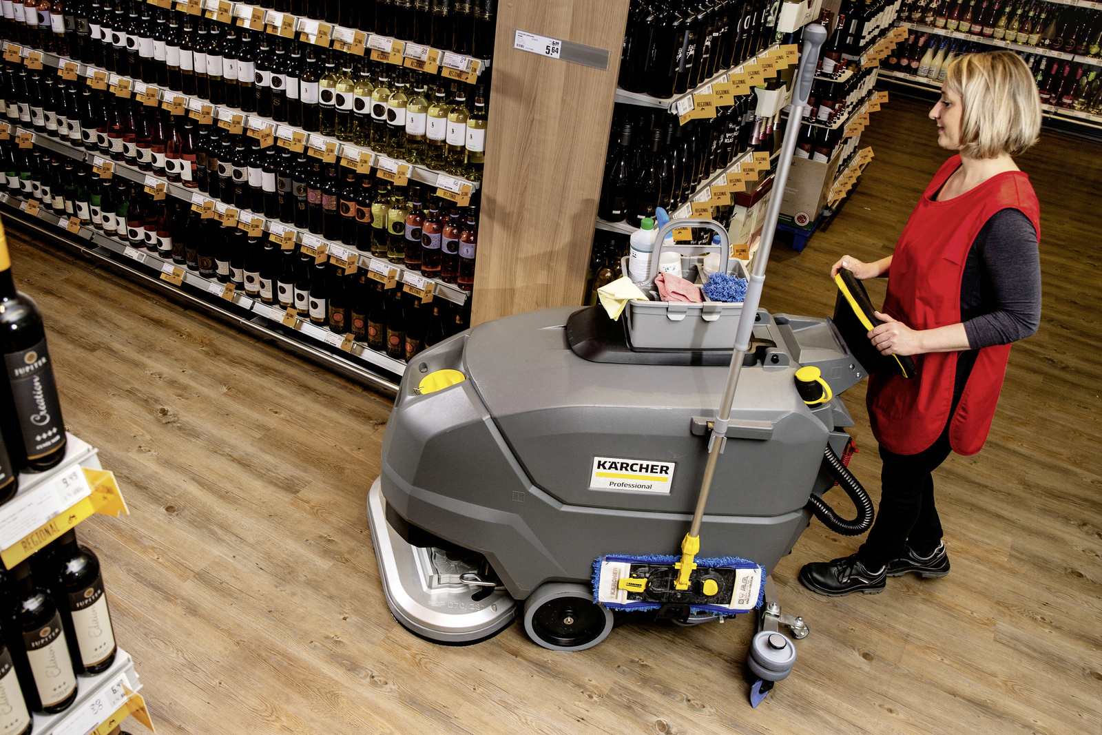 Scrubber dryer in use A person operating a scrubber dryer from Kärcher