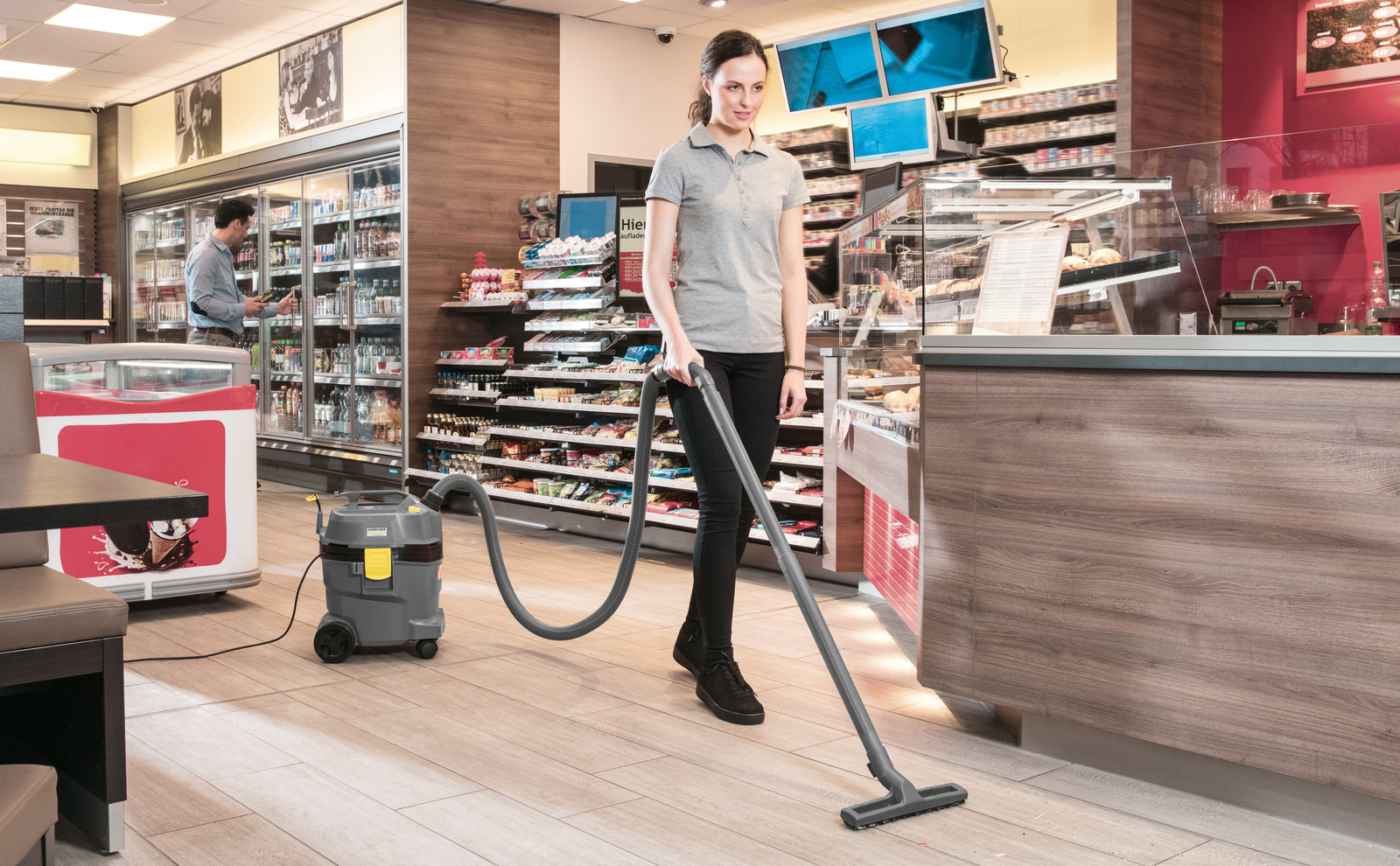 Cleaning a sales room A person cleaning a sales room with a wet/dry vacuum cleaner