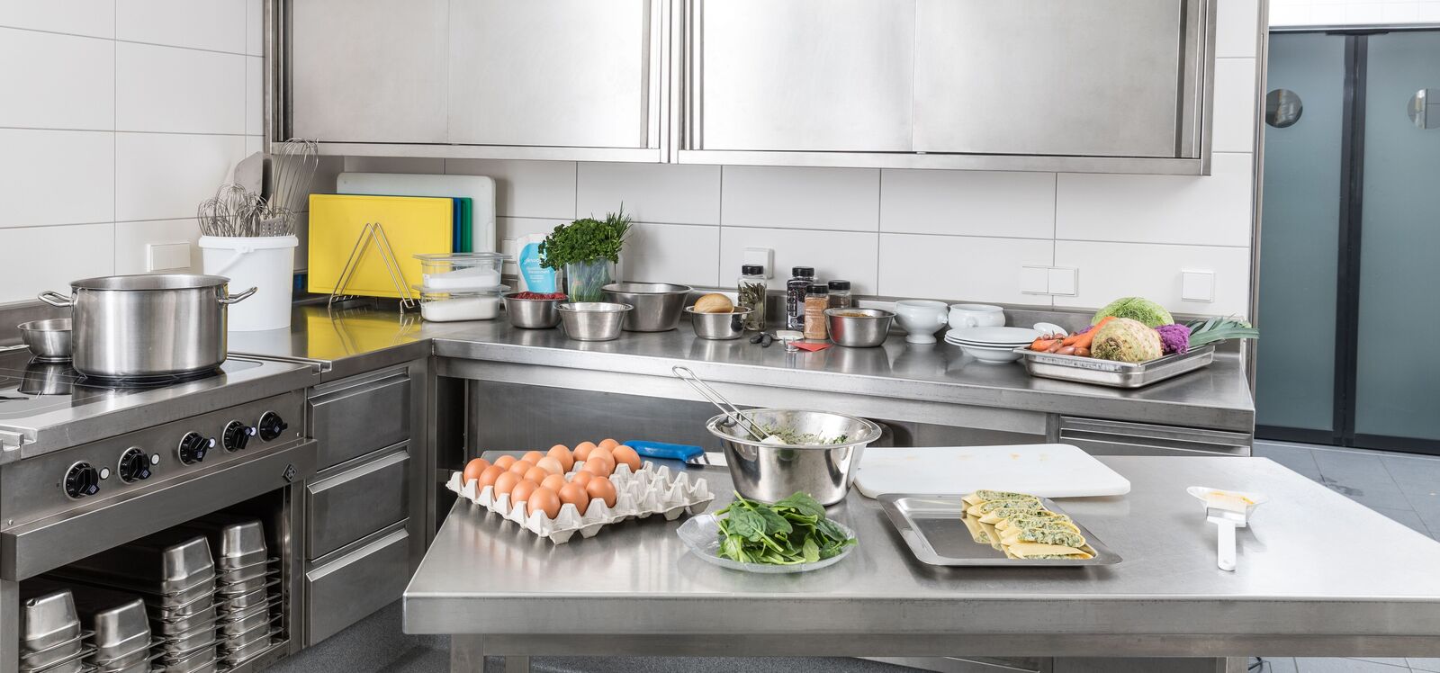 Küchenreinigung Eine Grossküche mit verschiedenen Küchenutensilien und Lebensmitteln