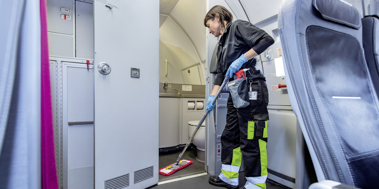 Toilet cleaning A person cleaning the toilet area with a mop