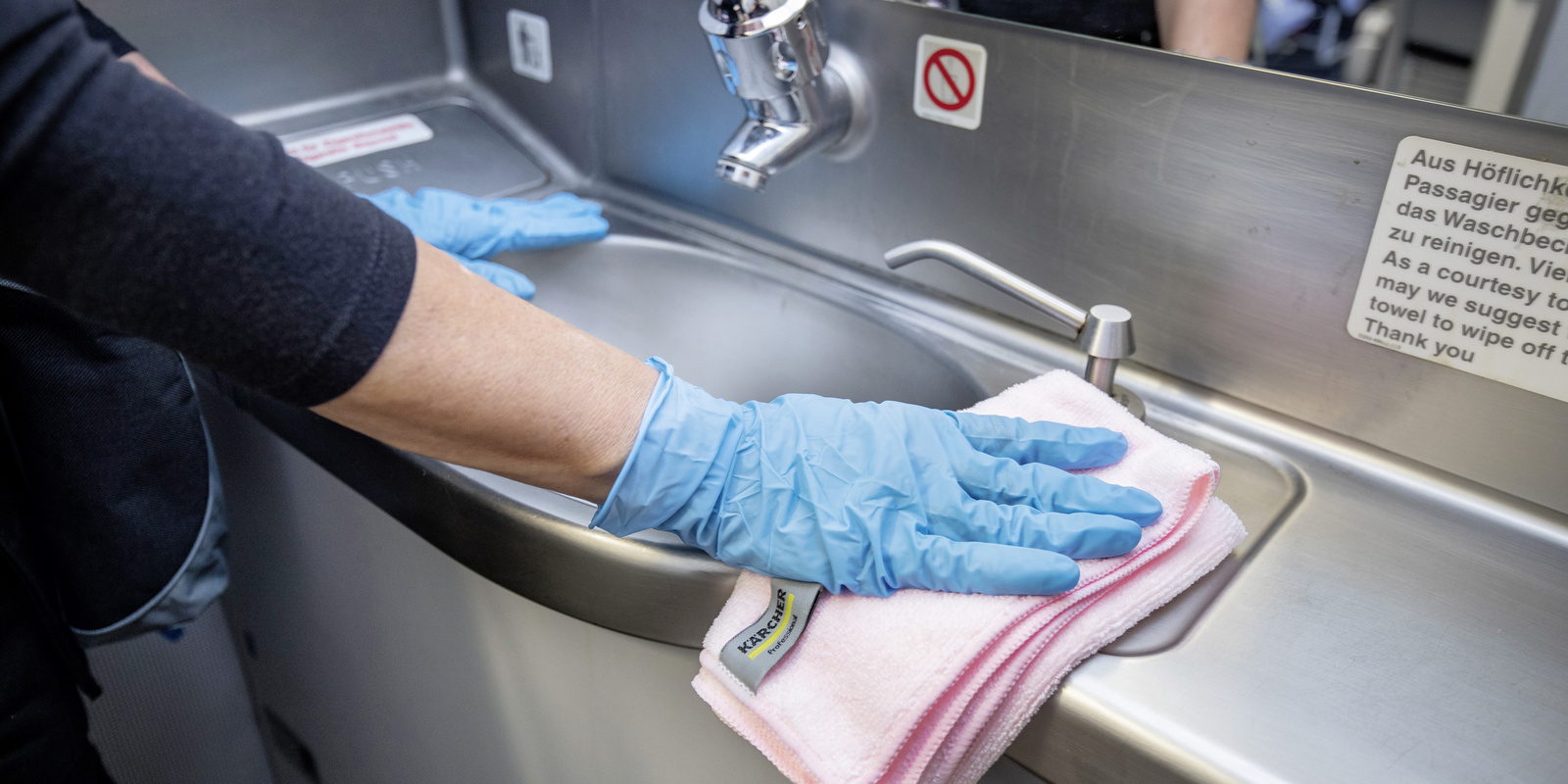 Cleaning of sinks A person cleaning a sink with a microfiber cloth