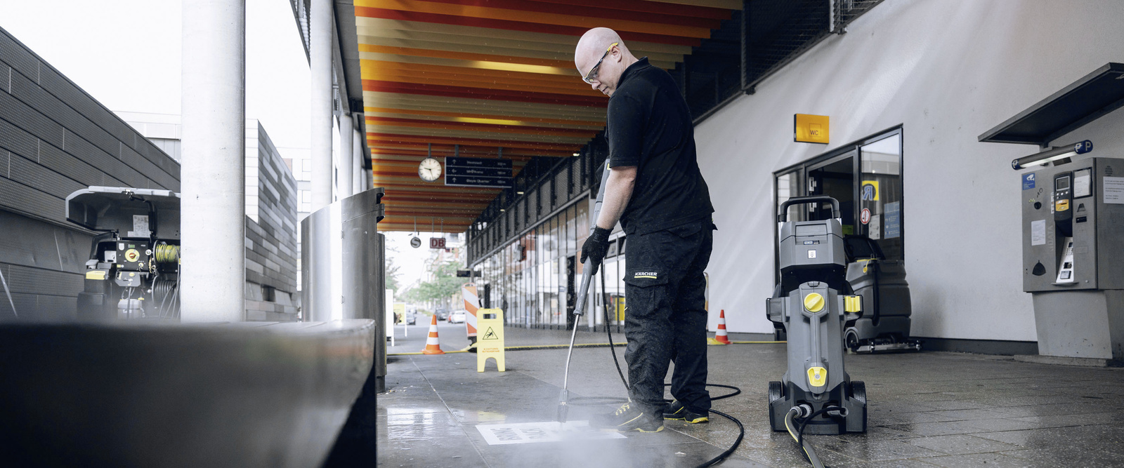High-pressure cleaner in use A person cleans a rail station area with a Kärcher high-pressure cleaner