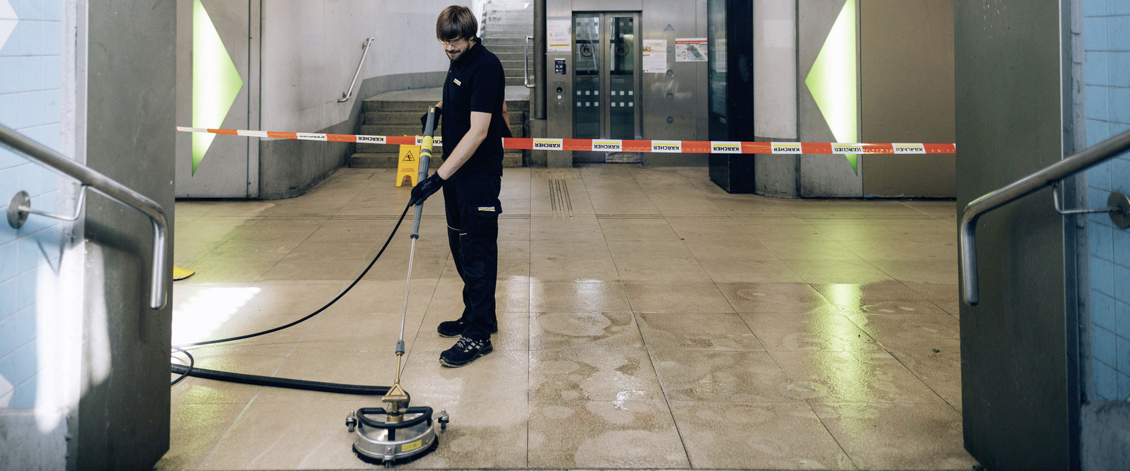 Manual sweeper A person operates a manual sweeper in an underpass