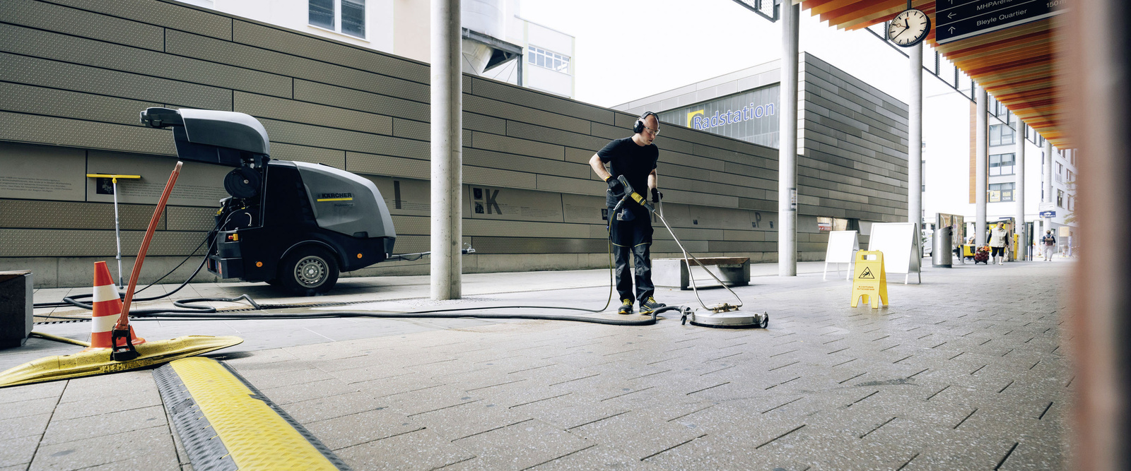 Manual sweeper A person cleans a station area with the use of a hand sweeper