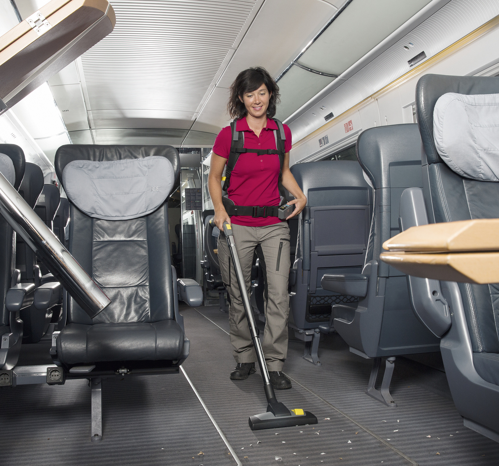Backpack vacuum cleaner A person cleaning the interior of a train with a backpack vacuum cleaner