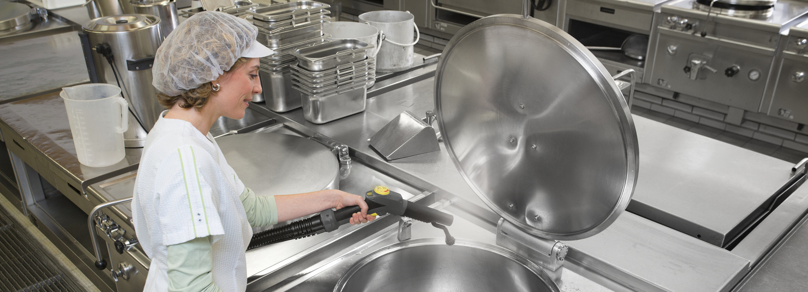 Steam cleaner in use A person is cleaning kitchen utensils with a Kärcher steam cleaner