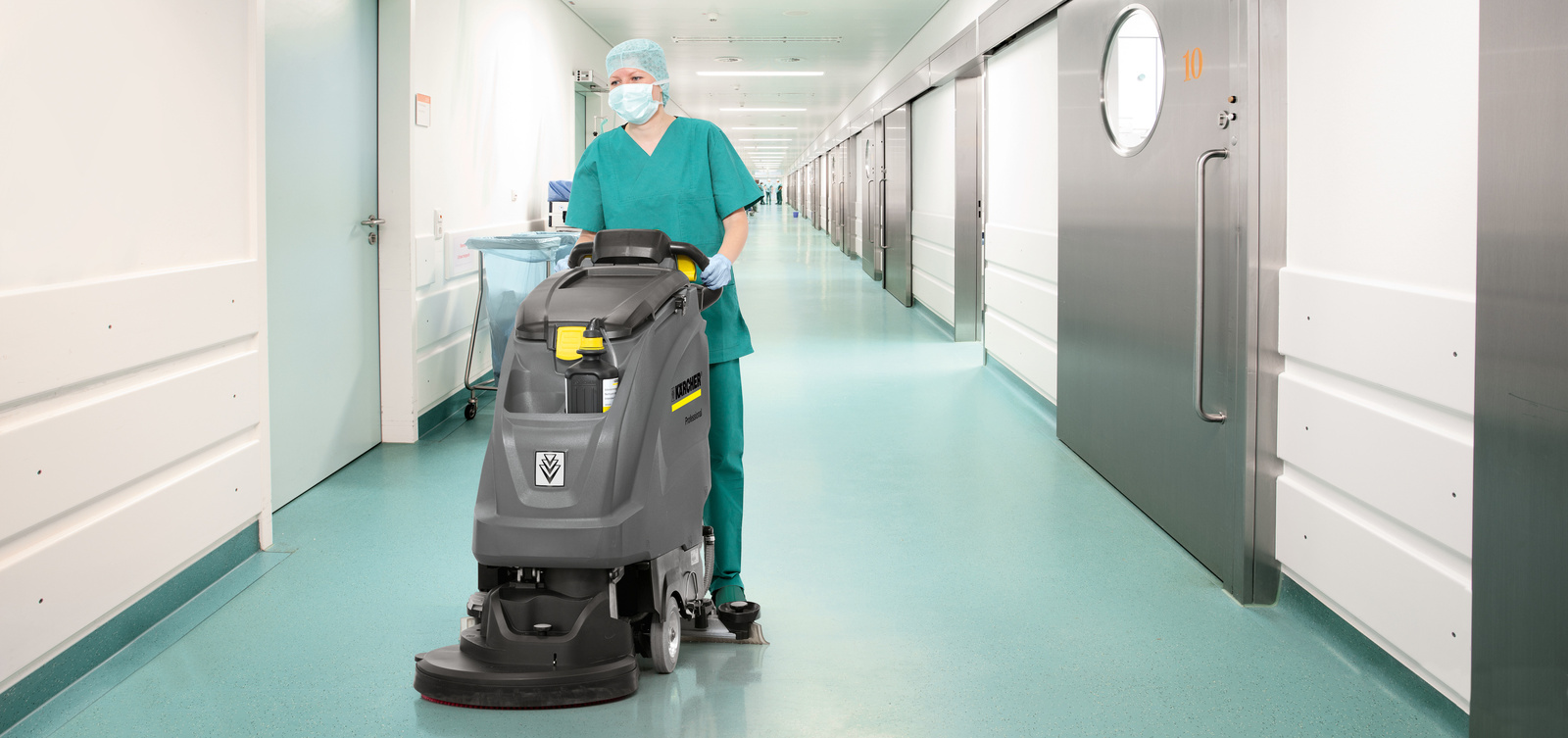 Cleaning in the operating room area with a scrubber dryer A person is cleaning the floor in the operating room area with a scrubber dryer