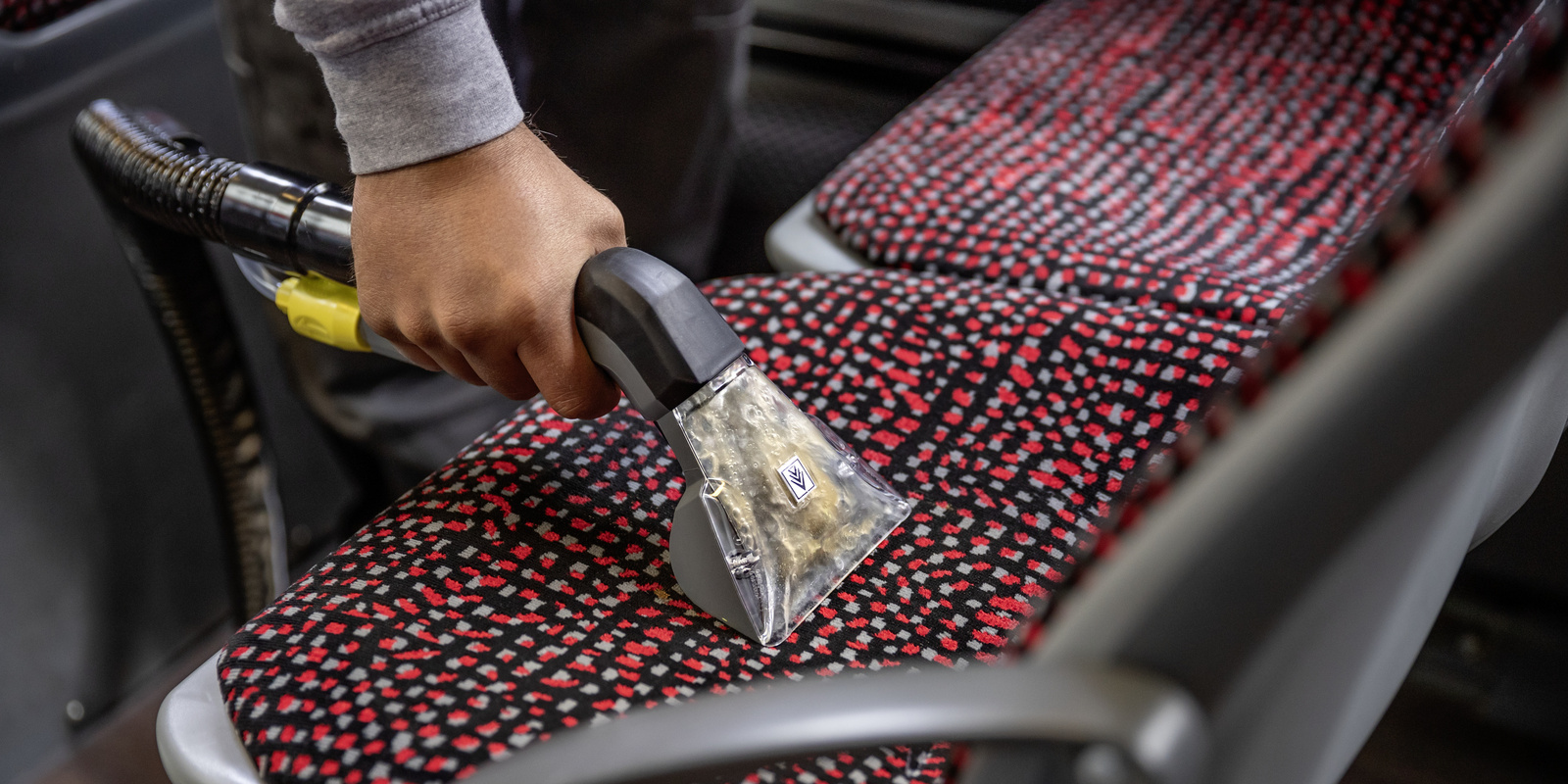 Cleaning the upholstery A person cleaning the upholstery of a seat with a mini scrubber dryer