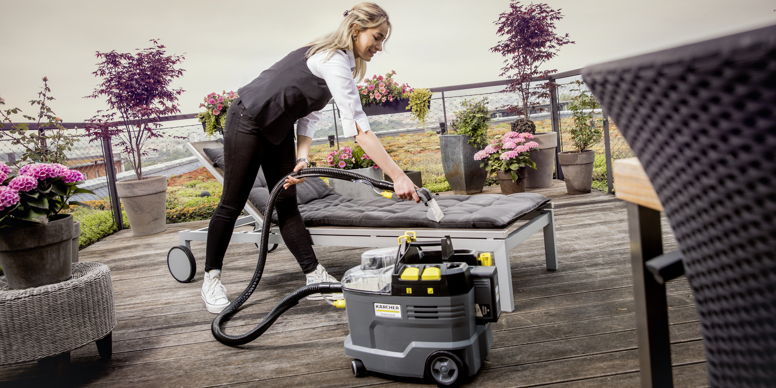 Upholstery cleaning with a spray extraction device A person operating a Kärcher spray extraction device