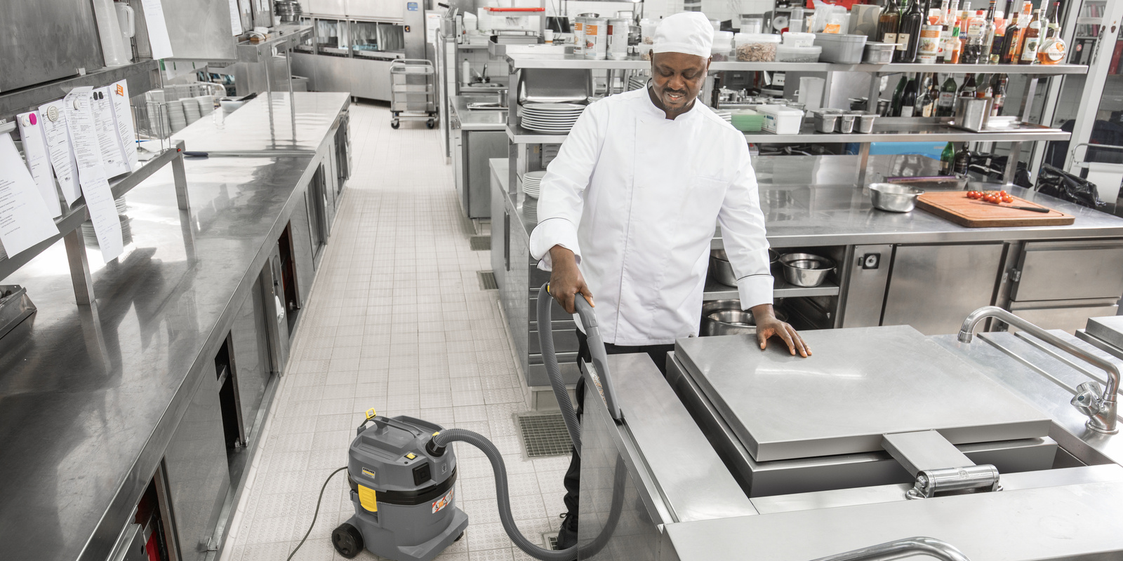 Dry vacuum cleaner in use A person cleaning a surface in the kitchen with the dry vacuum cleaner