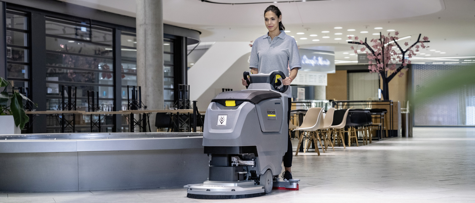 Cleaning with a scrubber dryer A person operating a Kärcher scrubber dryer