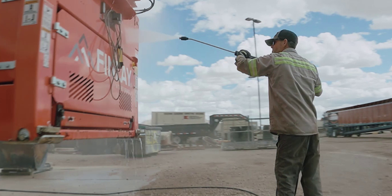 Heavy-Duty Cleaning A worker uses a Landa hot water diesel-powered pressure washer to clean industrial equipment