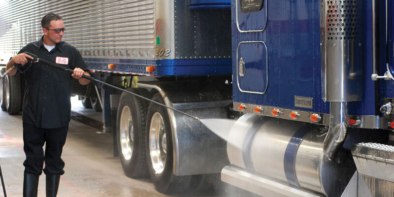 Cost-Effective A man sprays down a semi truck