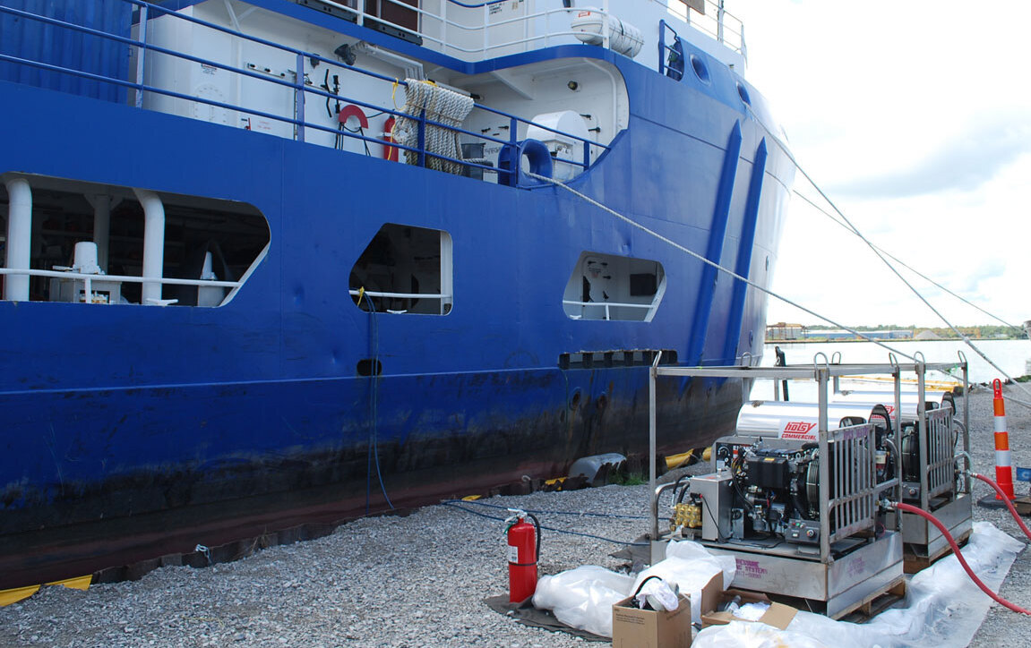 Pressure washers for transportation challenges Two Hotsy pressure washers sit outside a shipping vessel