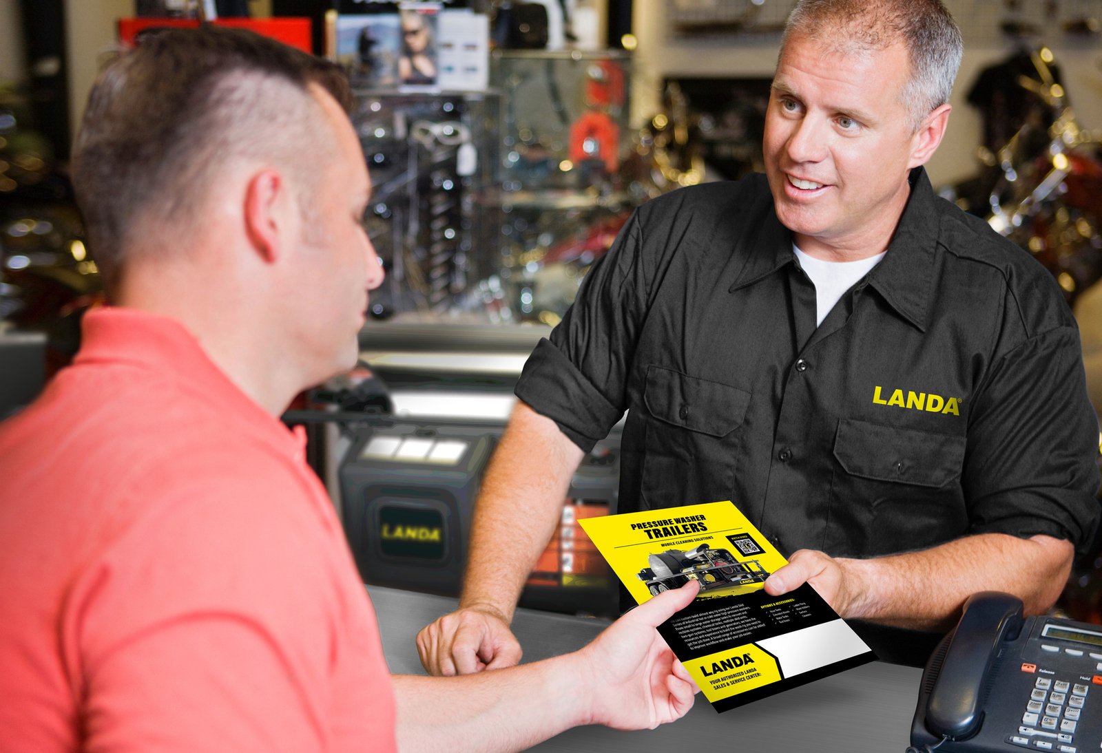 A Landa dealer hands a customer a flyer