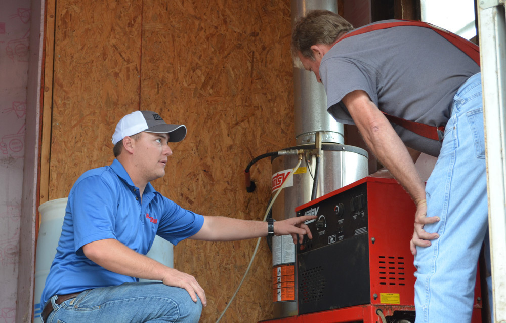 Request a Hotsy pressure washer demo A Hotsy dealer demonstrates a pressure washer for a customer