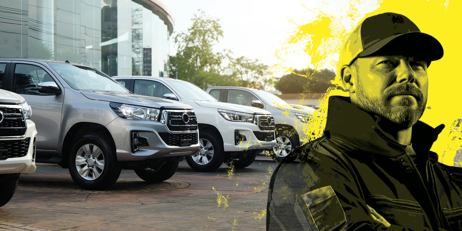 automotive industry worker next to a series of pickup trucks