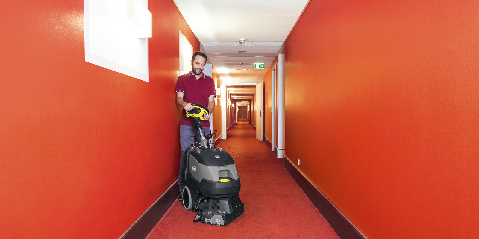 Floor cleaning with a scrubber dryer A person cleaning the carpet with a Kärcher scrubber dryer