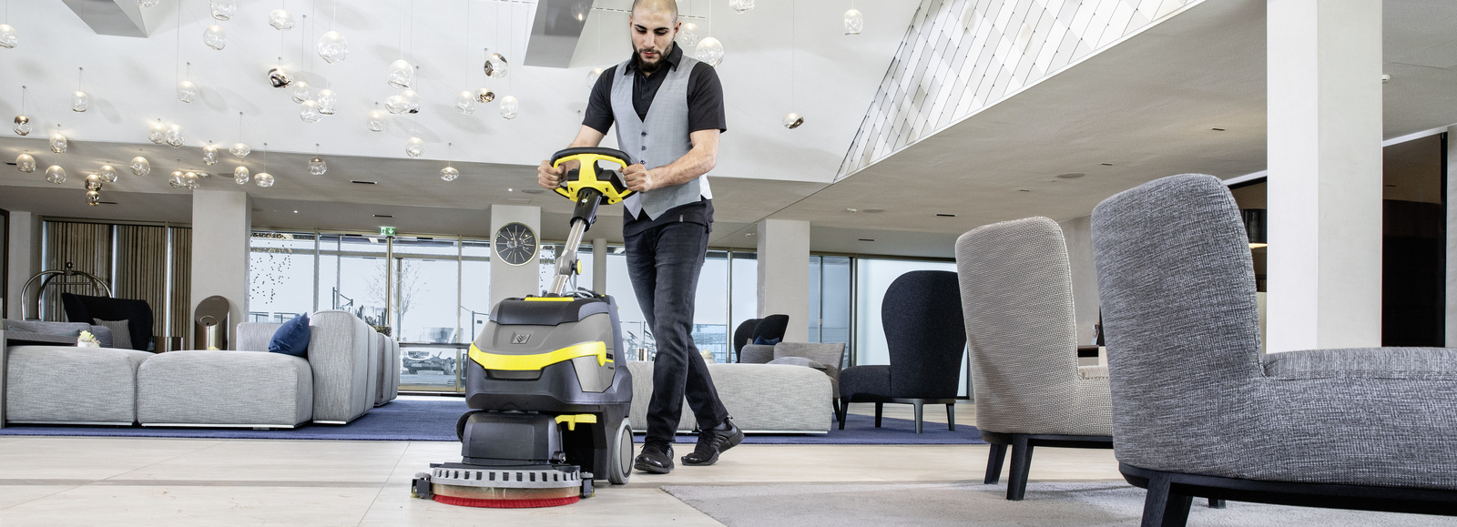 Scrubber dryer A man cleaning a hotel area with a scrubber dryer