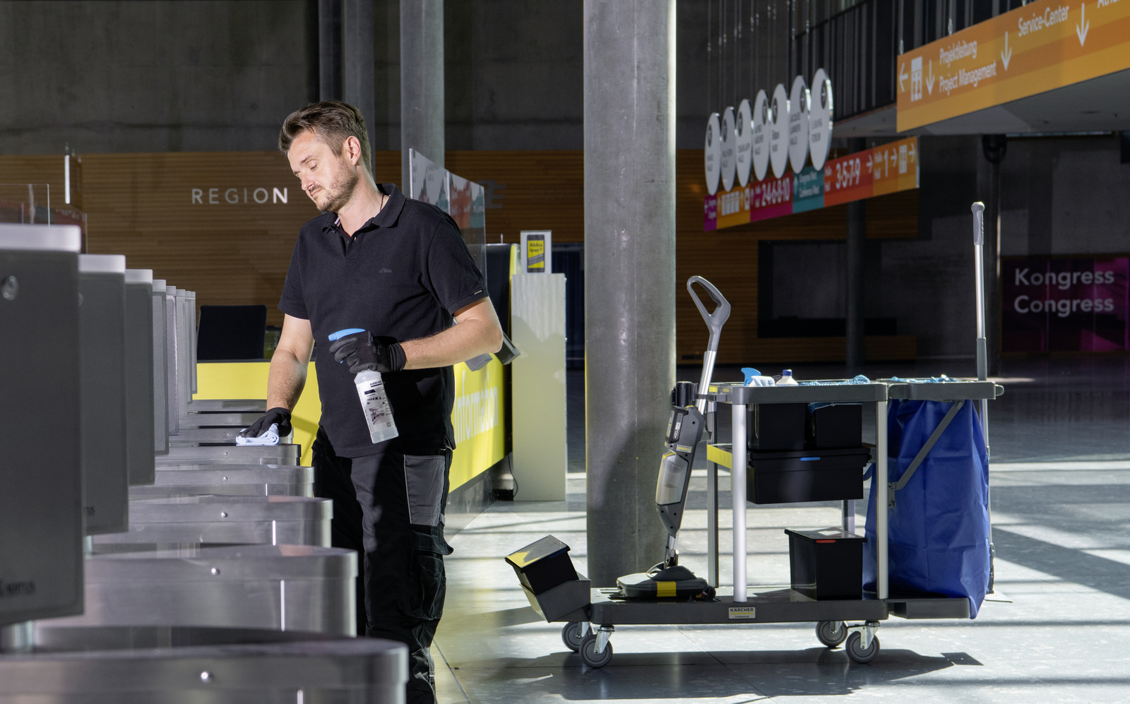 Cleaning cart in use A man cleaning a surface with a microfiber cloth and cleaning agent